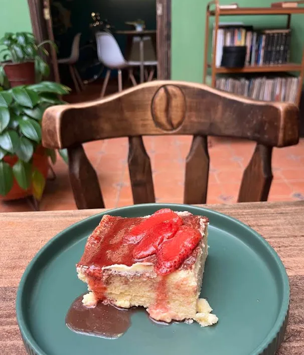 Cheesecake con salsa y fresas sobre plato verde